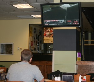 <p> Junior Brian DeVinny watches the news while eating lunch at Scooters.</p>