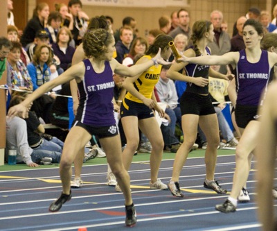 Senior Kelly Russ completes a successful hand off to senior Nikki Arola in the women's 4x400-meter relay.  It went on to place first setting a Recreational Center record and NCAA provisional time of 3:57.02. (Josh Kleven/TommieMedia) 