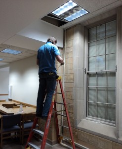 A physical plant employee installs new electrical outlets in the O'Shaugnessey-Frey Library. (Tom Graves/TommieMedia)