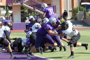 Senior running back Colin Tobin leaps over a pile of lineman against St. Olaf and clears the goal line, scoring one of his four touchdowns. (Rita Kovtun/TommieMedia)