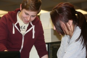 IRT student workers Lucas Estrem and Grace Gaslin review how to sync St. Thomas accounts to smartphones. (Anastasia Straley/TommieMedia)