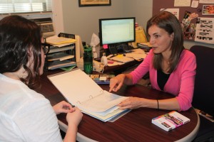 St. Thomas study abroad adviser Sarah Huesing talks with an Office of International Education student employee about course approval documents. Huesing helps students that decide to extend their stay to get courses approved. (Heidi Enninga/TommieMedia)