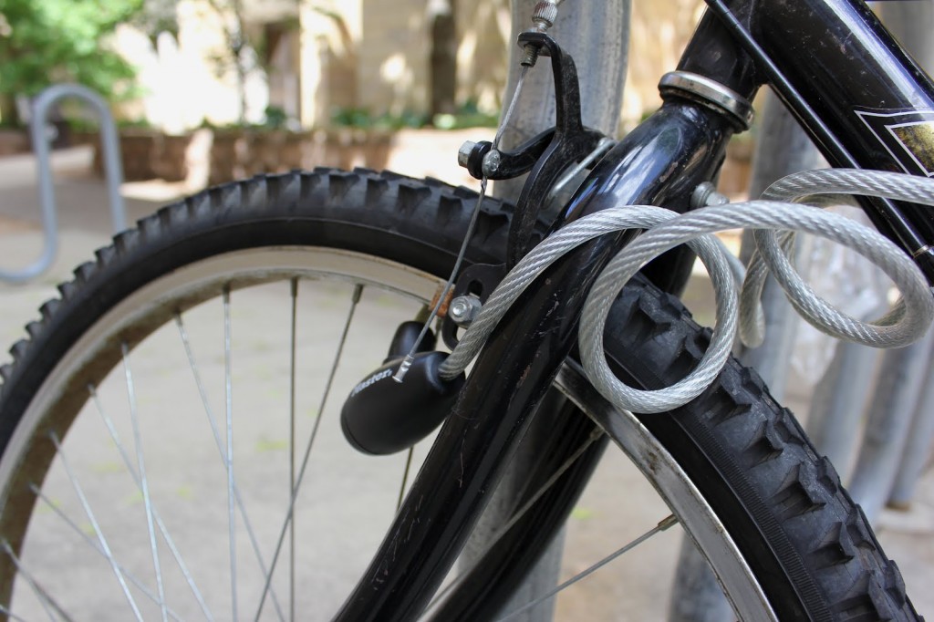 <p>A wire lock secures a bike on campus outside of the O'Shaughnessy Educational Center.  According to Public Safety, in May 2012 alone, 15 bikes were stolen on campus. (Hannah Anderson/TommieMedia)</p>