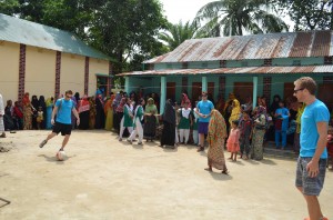 <p> Citizens of Bangladesh surround St. Thomas alumni Alex Daley (Left), Matt Scott (MIddle), and John Sunder (Right) as they kick the soccer ball around in a local village. While Sunder has no relation to Dribble Daily, he enjoys a fun game of soccer in efforts to promote community relations. The passion for soccer and extreme interest for creating clean areas for recreation sparked the idea to help out those who are less fortunate. (Photo courtesy of dribble daily.org)</p>