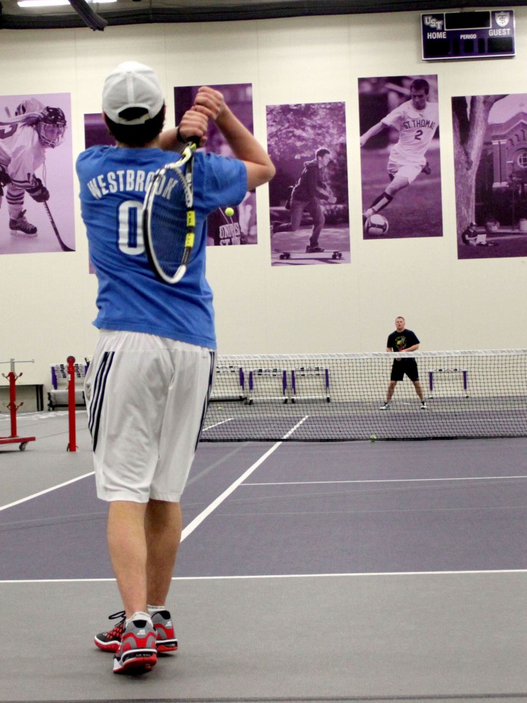 Brendan Hollidge and Matt Goldschmidt warm up by serving at practice. The Tommie men's and women's tennis teams started their seasons out strong, posting victories in both their opening matches. (Sean Crotty/TommieMedia)