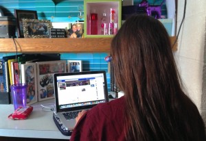 Freshman Lydia Swanson scrolls through the University of St. Thomas Confessions Facebook page. The page lets students anonymously post confessions. (Zach Zumbusch/TommieMedia)