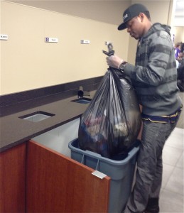 Senior Gauthier Mubwa picks up a bag of recyclables. (Kayla Bengtson/TommieMedia) 