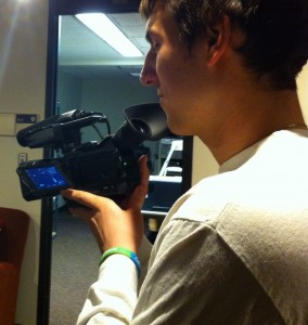 Sophomore Austin Riordan prepares his camera before going out to shoot promotional videos for Campus Ministry. Campus Ministry started a YouTube series to answer students' questions about God, the Catholic Church, or anything pertaining to life in general. (Stephanie Dodd/TommieMedia) 
