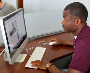 To get inspiration for his speech, Tommie Award winner Eyo Ekpo, watches a video on Youtube. Ekpo said he may be absent at the 2013 graduation ceremony because of track and field NCAA Championships. (Eden Checkol/TommieMedia)