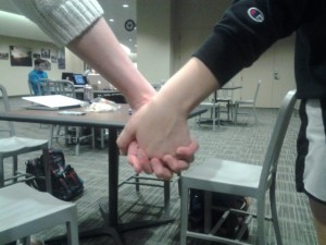 Two students hold hands in the Anderson Student Center on Monday, the same day the state Senate passed a bill to Gov. Mark Dayton that will allow gay marriage. Same-sex marriage will be legal starting Aug. 1 of this year. (Anastasia Straley/TommieMedia)