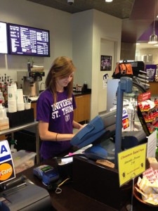 Junior Lauren Bogumill checks out a customer at the Summit Marketplace. Employees at the Summit Marketplace will experience policy changes that deny them the opportunity to do homework while on the clock. (Zach Zumbusch/TommieMedia) 