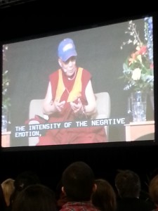 The 14th Dalai Lama speaks to an audience of students and educators Sunday. Macalester gifted His Holiness with a bright blue baseball cap along with an honorary degree. (Caroline Rode/TommieMedia) 