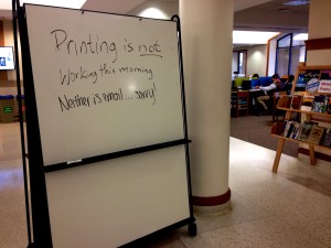 A sign posted inside O'Shaughnessy-Frey Library notifies students of today's server outage. The outage lasted several hours, and prevented students and faculty from printing, checking email and accessing Blackboard. (Jake Remes/TommieMedia) 