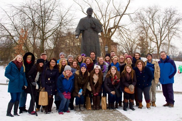 The class poses in front of a statue of St. John Paul II in Poland this past January. Media approached the group for interviews nearly every day. (Paul Wojda)