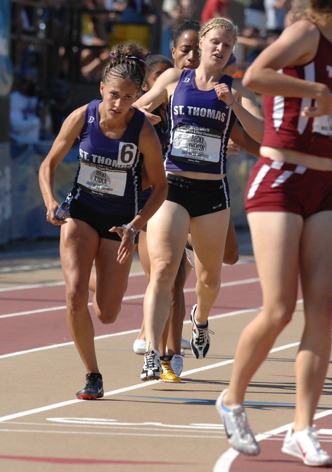 Senior Nikki Arola starts her leg of the 4 x 400 relay after taking the baton from junior Becky Theisen. (Photo courtesy of the Baldwin-Wallace College Athletic Department)