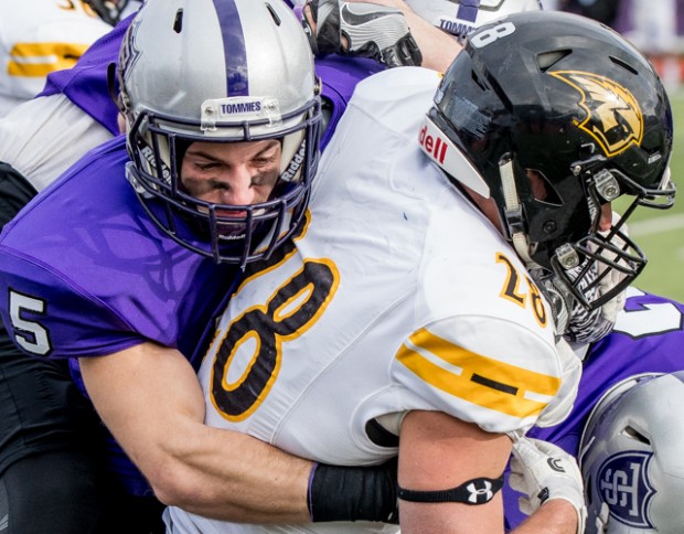 St. Thomas defensive back Chris Fondakowski tackles University of Wisconsin-Oshkosh running back Devon Linzenmeyer. The Tommies trailed behind Oshkosh 24-10 at halftime. (Carlee Hackl/TommieMedia) 