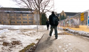 One student maneuvers around a puddle on a Lower Quad sidewalk. (John Kruger/TommieMedia)