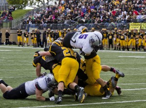 Running back Jack Kaiser soars over Gustie defenders in the 2013 matchup. This year, the Tommies will look to slow down prolific quarterback Mitch Hendricks. (Andrew Stafford/TommieMedia)