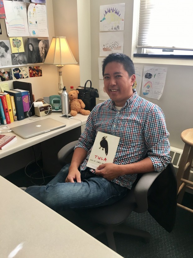 Professor Christopher Santiago poses with a copy of his book Tula. Tula won the Lindquist & Vennum Prize for Poetry. (Lydia Lockwood/TommieMedia) 