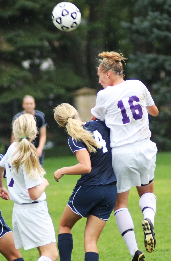 <p>Sophomore midfielder Anna Strehlow jumps higher than an Eau Claire defender to head the ball to a teammate. (Miles Trump/TommieMedia)</p>