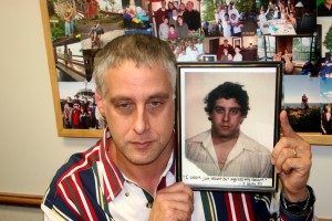 Assistant Dean Jim Sachs holds a picture of himself as a young man. It reads, "I wasn't just vacant but aggressively vacant." Sachs keeps the picture in his office to remind him of his days as a "major-league partier." (Theresa Malloy/TommieMedia)