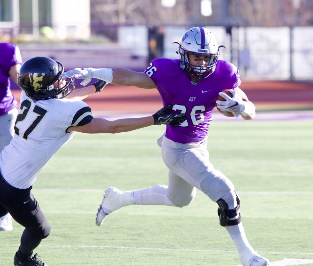 Runningback Josh Parks pushes off a St. Olaf defender as he carries the ball down the field. Parks had 110 rushing yards for the Tommies in the first half. (Meghan Vosbeek/TommieMedia) 