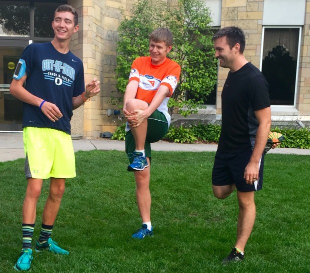 Juniors Zach Lang, Connor Theisen and friend Larry Martini stretch in the upper quad before a morning run. The St. Thomas group is collecting money for nonprofit World Vision by running in the Medtronic Twin Cities Marathon on Oct. 4. (Claire Noack/TommieMedia) 
