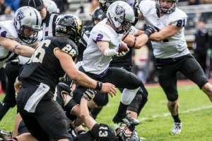 Running back Nick Waldvogel steps over a flattened St. Olaf defender during last year's game. The Tommies will go for their eighth straight win over St. Olaf Saturday. (Jake Remes/TommieMedia) 