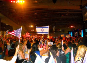 <p>Students wave flags and show support at a large summit event named "A Night to Honor Israel." (Courtesy of Angela Hasek)</p>