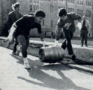 <p>Two students roll a keg down a campus sidewalk for the homecoming keg roll competition (Omar Marei/The Aquin)</p> 