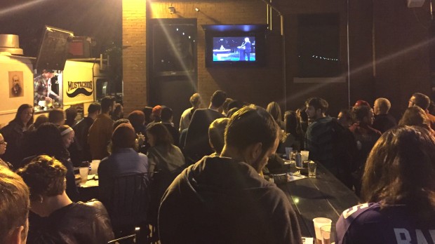 A crowd congregates in front of a TV at Nomad World Pub to watch the first presidential debate on Monday. The pub event was hosted by MPR and featured games such as debate bingo. (Spencer Flaten/TommieMedia) 