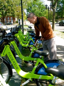 Conservation geography professor Paul Lorah unlocks a Nice Ride bike at a local kiosk. There are three Nice Ride bike locations near the St. Thomas area. Professor Lorah's class received a $20,000 grant from the campus sustainability fund to contribute to discounted passes for the bikes. (Zach Zumbusch/TommieMedia)