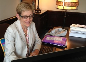 President Julie Sullivan works at the president’s desk in Aquinas Hall. In Tuesday's convocation speech, Sullivan announced that she will work on St. Thomas' Minneapolis campus one day a week. (Heidi Enninga/TommieMedia) 