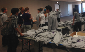 St. Thomas students try on sweatshirts to decide on sizes at the homecoming sweatshirt pickup on Sunday. This year, students were required to sign up for the Tommie Challenge in order to receive a sweatshirt. (Gabrielle Martinson/TommieMedia)