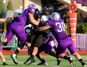 Tommie defenders crush a Ole running back in last year's meeting between these two teams. St. Thomas was victorious 35-21 at O’Shaughnessy Stadium in 2012. (Rosie Murphy/TommieMedia) 