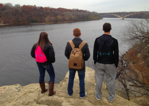 Holding HOPE founders Madison Bosshart, Kyle Andrews, and Bobby Mason overlook the Mississippi River sporting their drawstring bags for HOPE. The trio founded Holding HOPE this year to raise money to give hospitalized children an easier way to carry their medical equipment. (Luke Moe/TommieMedia) 