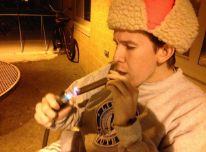 Junior Andy Brown lights one of his last legal cigars on campus. Brown said that he believes the smoking ban is "absurd." (Kayla Bengtson/TommieMedia)