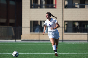 Senior Mary Grace Flesher scans the field for an open teammate in the soccer team's season-opener earlier this fall. Flesher has been a four-year starter for the soccer and hockey teams, and is currently helping the hockey build on their 5-3-1 start. (Jacob Sevening/TommieMedia)