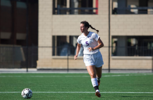 Senior Mary Grace Flesher scans the field for an open teammate in the soccer team's season-opener earlier this fall. Flesher has been a four-year starter for the soccer and hockey teams, and is currently helping the hockey build on their 5-3-1 start. (Jacob Sevening/TommieMedia) 