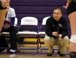 St. Thomas volleyball coach Thanh Pham crouches during last year's matchup against St. Mary's College. The team is looking to rebound after three early losses in its 2014 season. (Morgan Neu/TommieMedia)