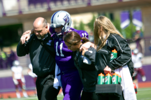 St. Thomas quarterback Matt O'Connell is carried off the field. O'Connell threw for 66 yards and a touchdown in the first half, along with 64 rushing yards. (Jake Remes/TommieMedia)