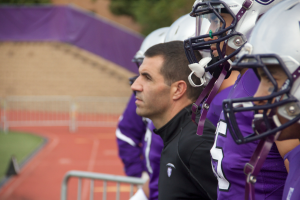 Coach Glenn Caruso walks with his team onto the field to face Wisconsin-La Crosse Saturday. In 2012, Caruso decided to make St. Thomas the first university in Minnesota to host a Tackle Cancer game. (Jake Remes/TommieMedia) 