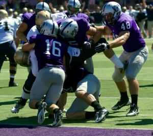 A swarm of Tommies make a goal line stand in their season-opener against Wisconsin Eau-Claire. Jim Rakow, St. Thomas head athletic trainer, said the training staff is confident in its focus on a new concussion program. (Jake Remes/TommieMedia)