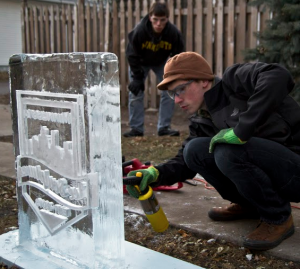 Robbie Harrell works on a sculpture as former partner Stu Lombardo looks on. The two started Minnesota Ice Sculptures last year. (Eric Wuebben/TommieMedia)