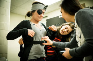 St. Thomas graduates Megan Coffman and Grace Vo assist a student preparing to participate in the study. Using the "Pirate Theory," they recently conducted a study to better understand why people might be afraid of the dark. (Courtesy of Mark Brown/University Relations)