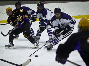 Forward Derek Jacobson pulls the puck out of the defensive zone in last year's game against Wisconsin-Stevens Point. The Tommies were one game away from a trip across the country to compete in the NCAA Division-III Frozen Four in Maine last year. (Eric Wuebben/TommieMedia)