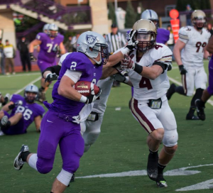 Running back Nick Waldvogel stiff-arms Cobber safety Bryce Hentges during a run in the fourth quarter of last year's game. Waldvogel ran for 100 yards on 15 attempts, including a touchdown in the Tommies' 34-20 win. (Andrew Stafford/TommieMedia)