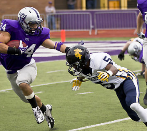 Running back Brenton Braddock stiff-arms a Carleton cornerback in last year's game. Coach Glenn Caruso said the Tommies will need to devote attention to Saturday’s game. (Eric Wuebben/TommieMedia) 