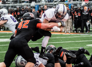 Running back Nick Waldvogel hops over Ulice Payne III for the Tommies’ first touchdown against Wartburg. Waldvogel accounted for 25 of St. Thomas’ 170 yards in the first half. (Jake Remes/TommieMedia)