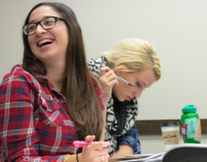 Seniors Gabriela Lozado and Cecelia Porter peer review papers in class. The two worked with the rest of the class to create a Facebook page raising awareness for Mexico's 43 missing students. (Simeon Lancaster/TommieMedia)